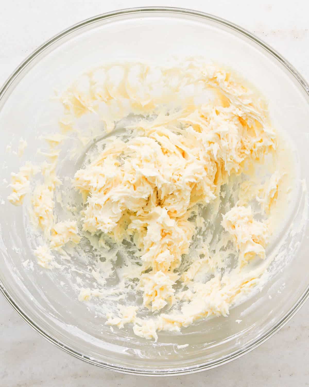making coconut frosting for coconut brownies - butter and sugar beaten together in a glass bowl
