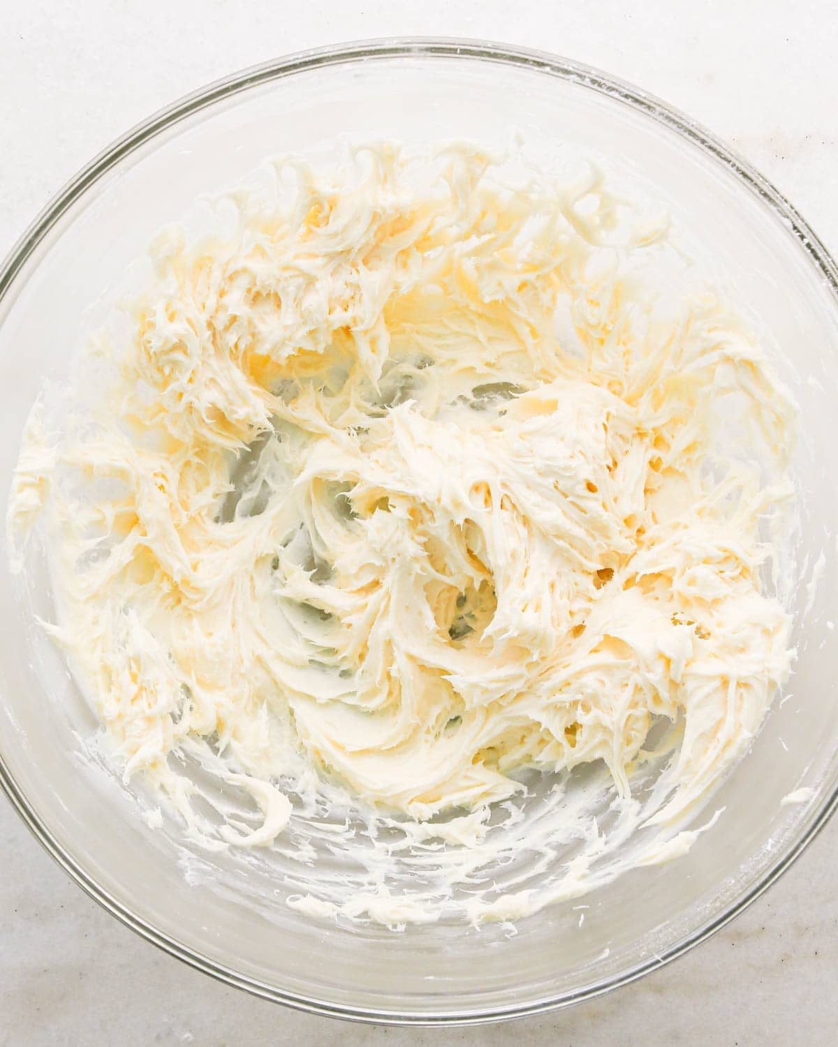 making coconut frosting for coconut brownies - butter and sugar beaten together in a glass bowl