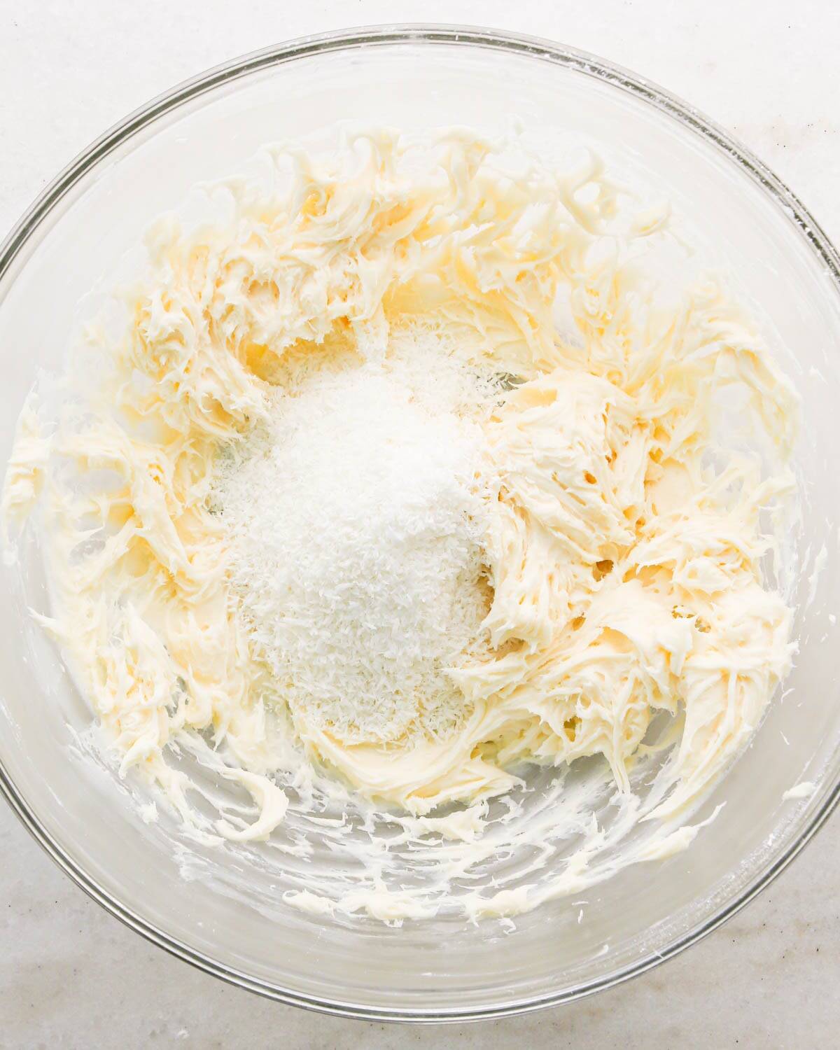 making coconut frosting for coconut brownies - shredded coconut added to the frosting before mixing