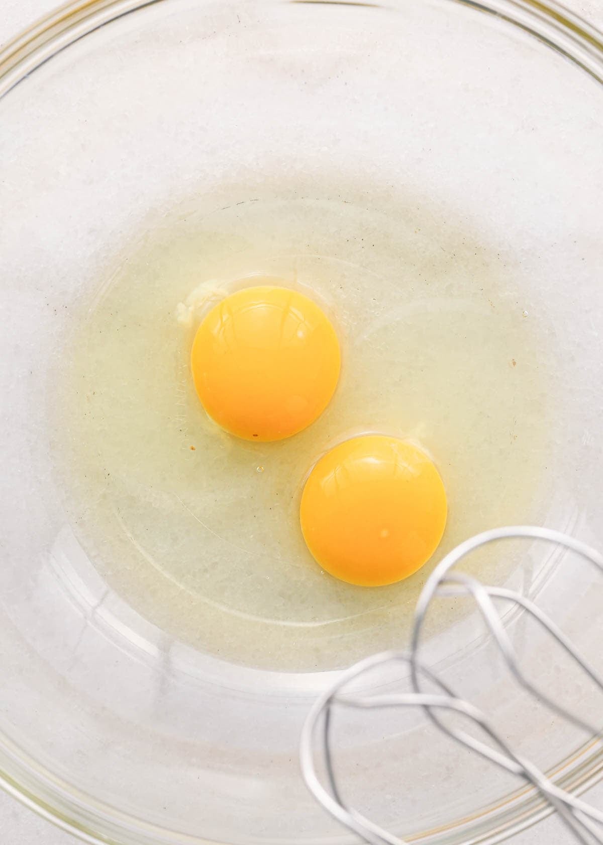 making coconut brownies - two eggs in a glass bowl 