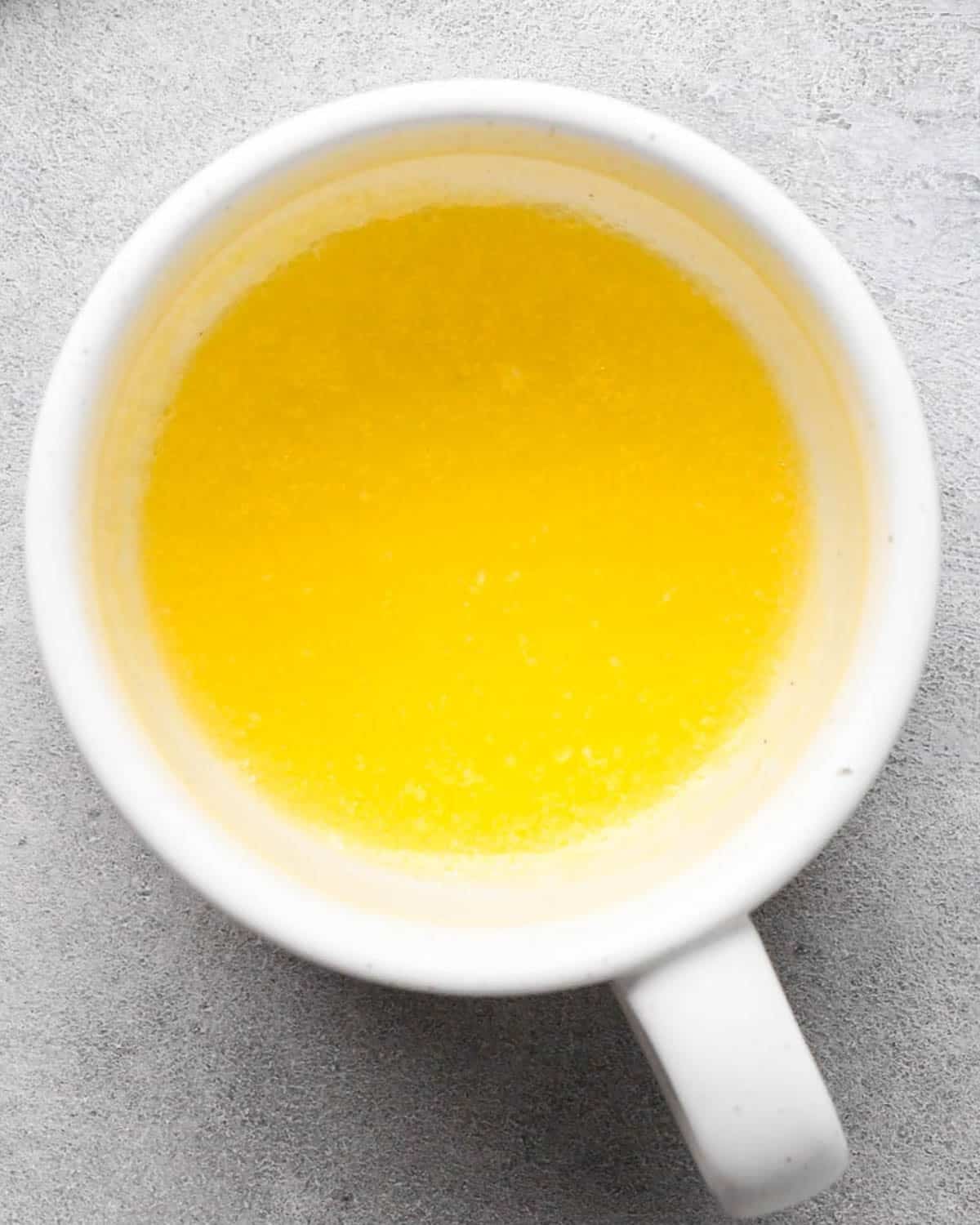 making a mug cookie - melted butter in a white mug