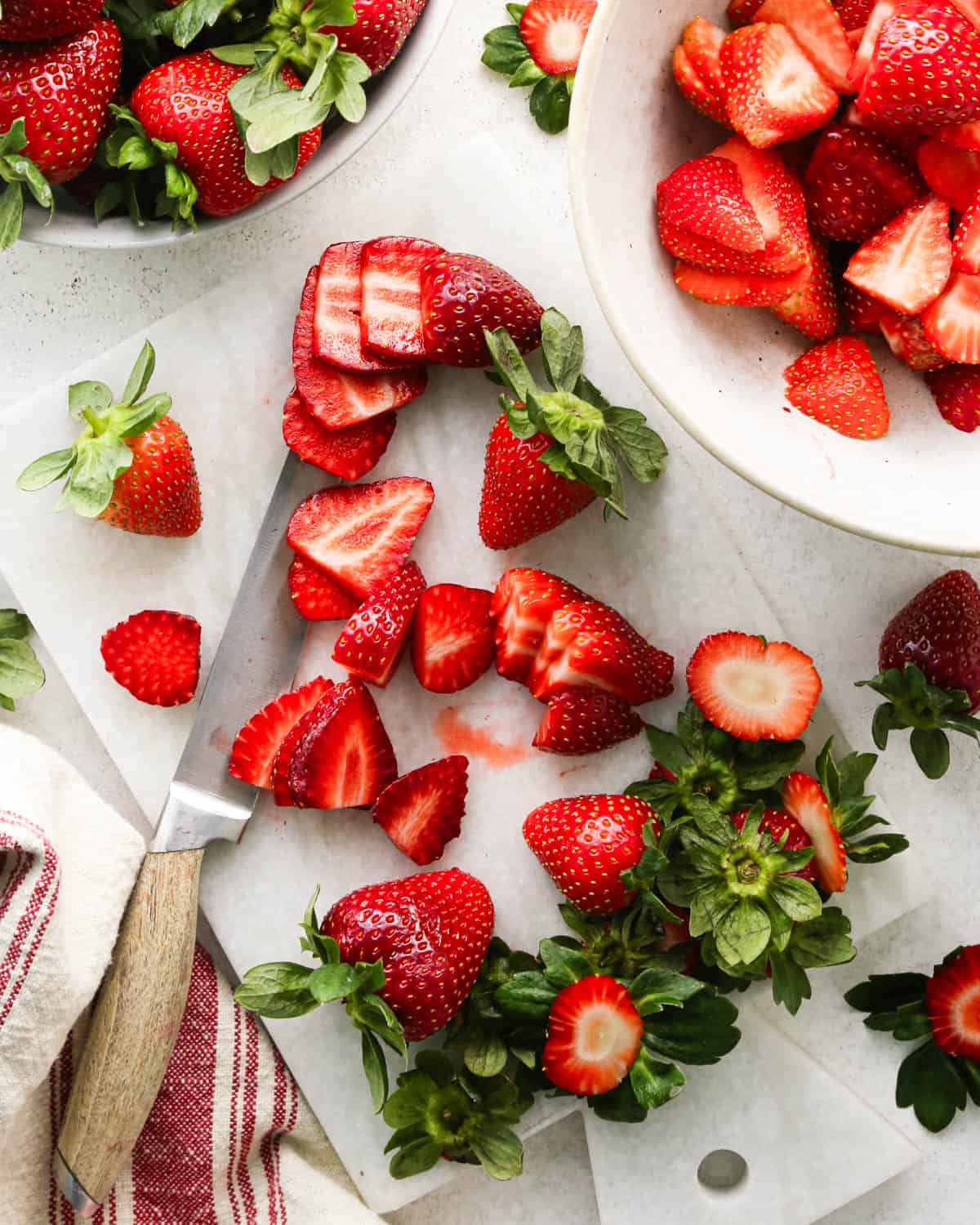how to make a trifle with berries - strawberries on a cutting board with a knife being sliced to use in this recipe