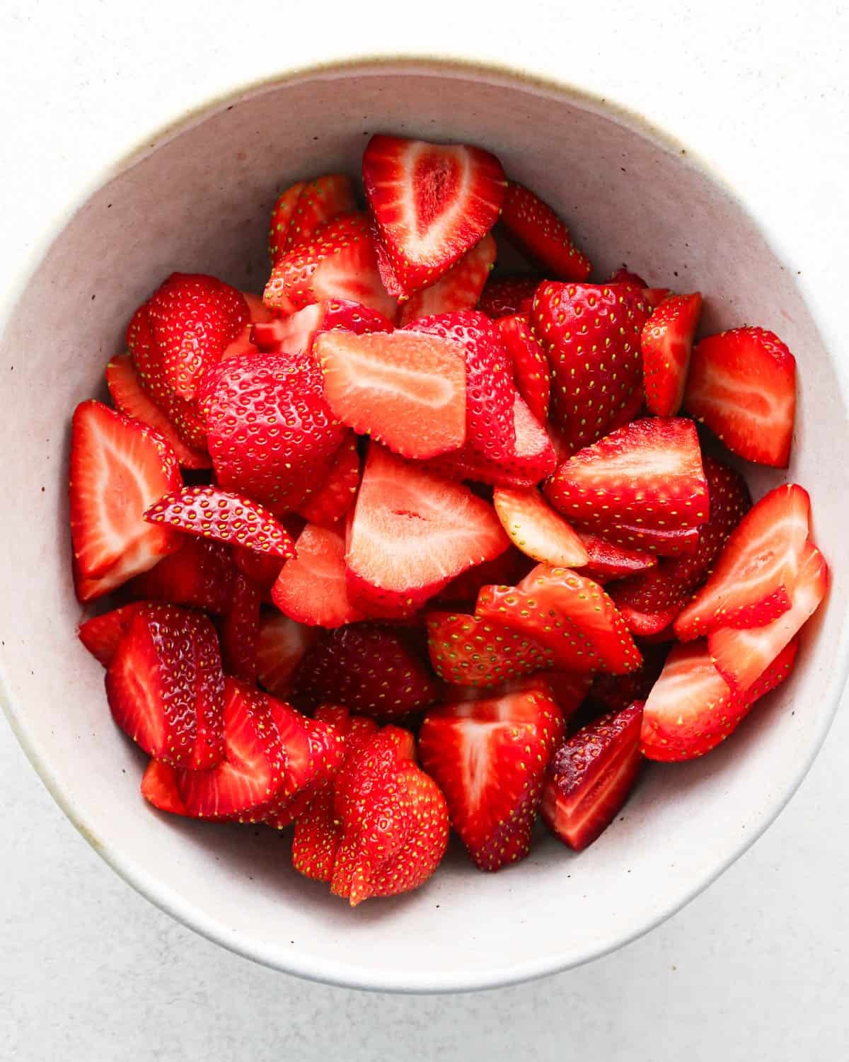 how to make a trifle with berries - sliced strawberries in a white bowl