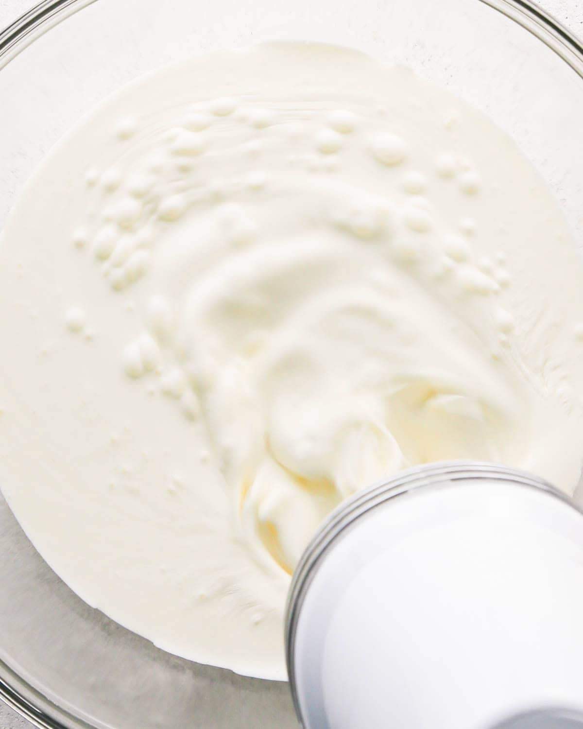 how to make a trifle with berries - making the whipped cream layer in a glass bowl, whipping the heavy cream