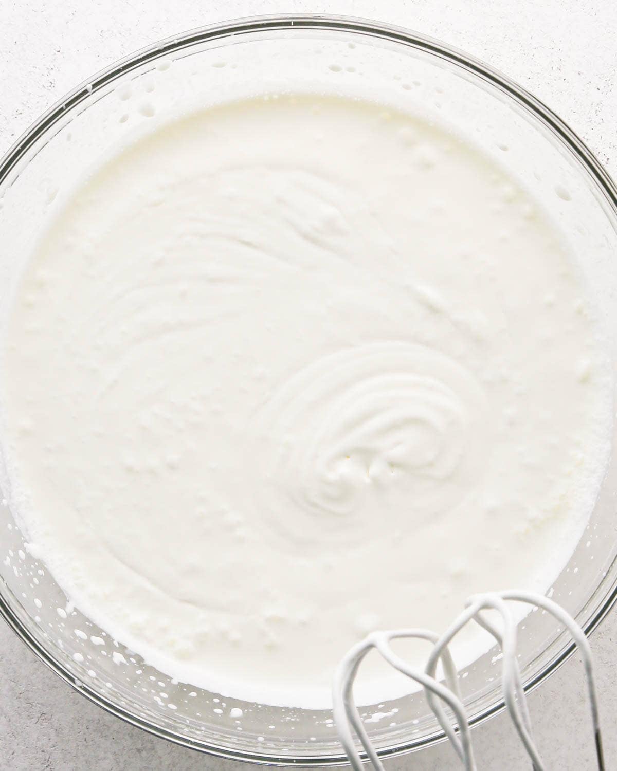 how to make a trifle with berries - making the whipped cream layer in a glass bowl, whipping the heavy cream