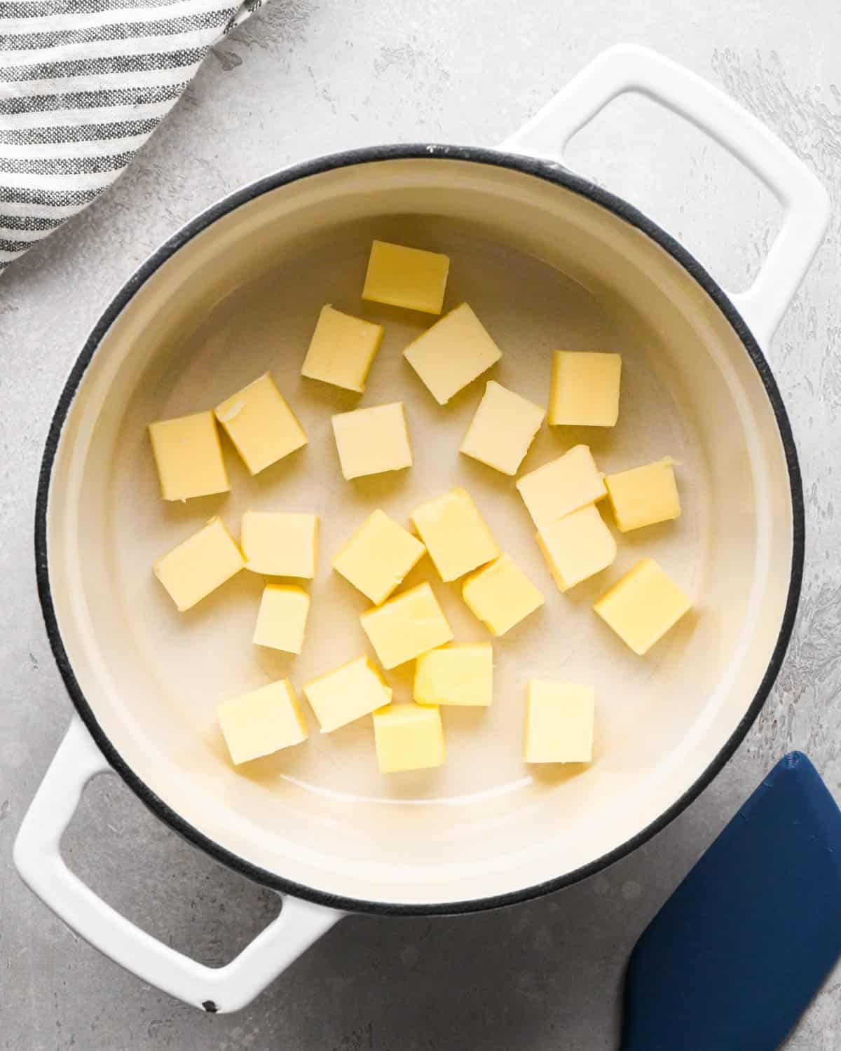 browning butter for brown butter brownies - cubed butter in a white pot