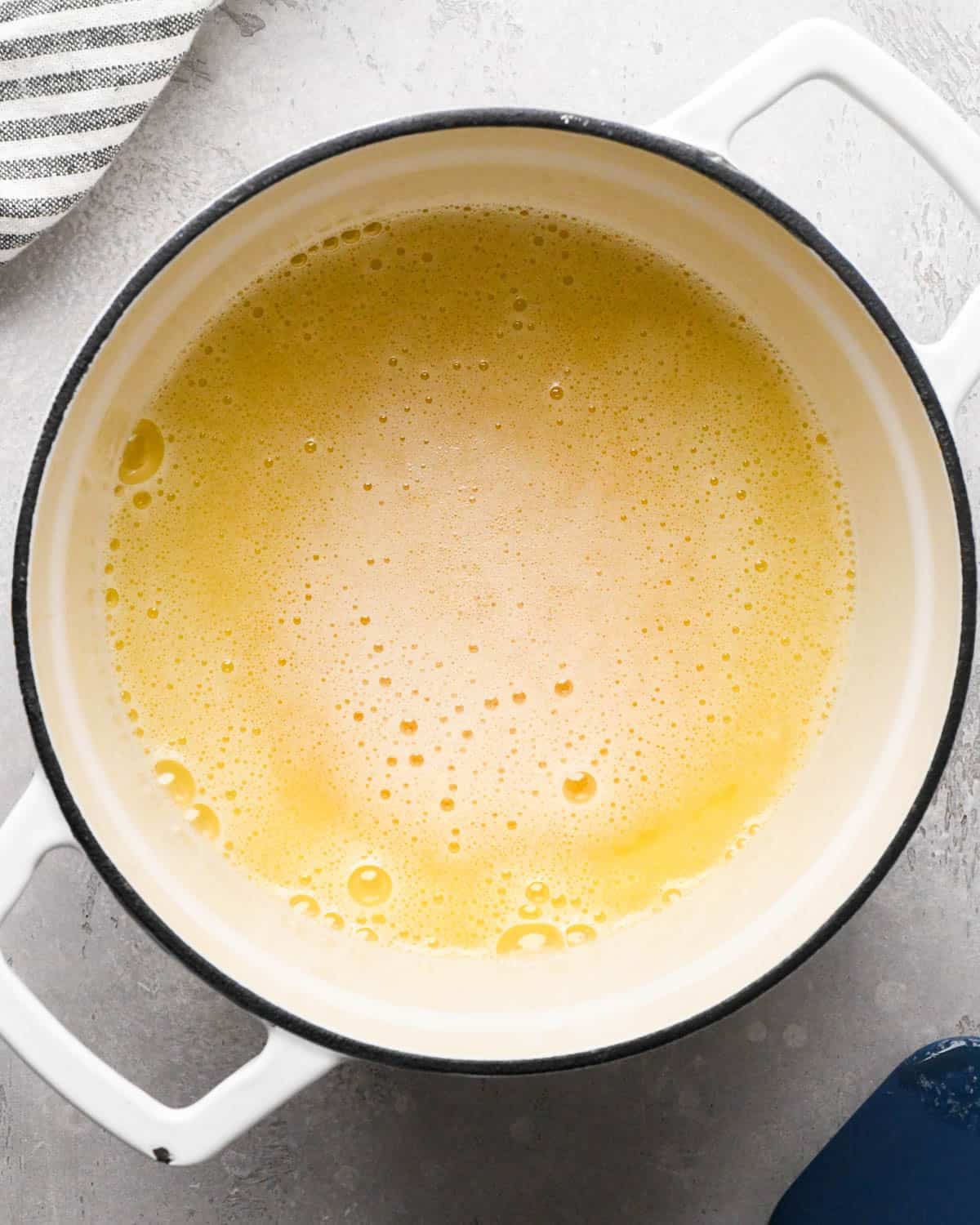 browning butter for brown butter brownies - melted, foamy butter in a pot