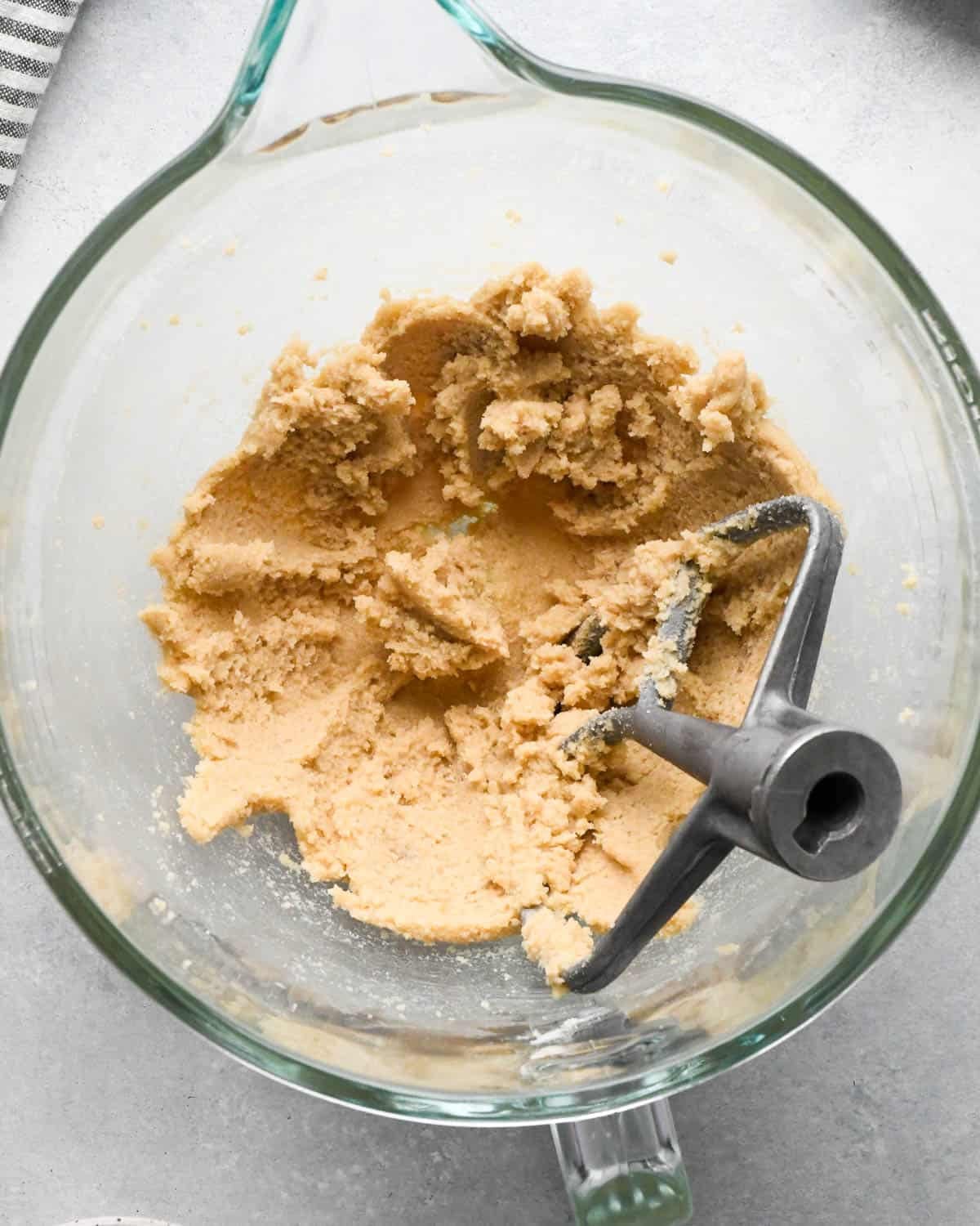 How to Make Chocolate Oatmeal Cookies - creamed butters and sugars in a glass mixing bowl with a paddle attachment