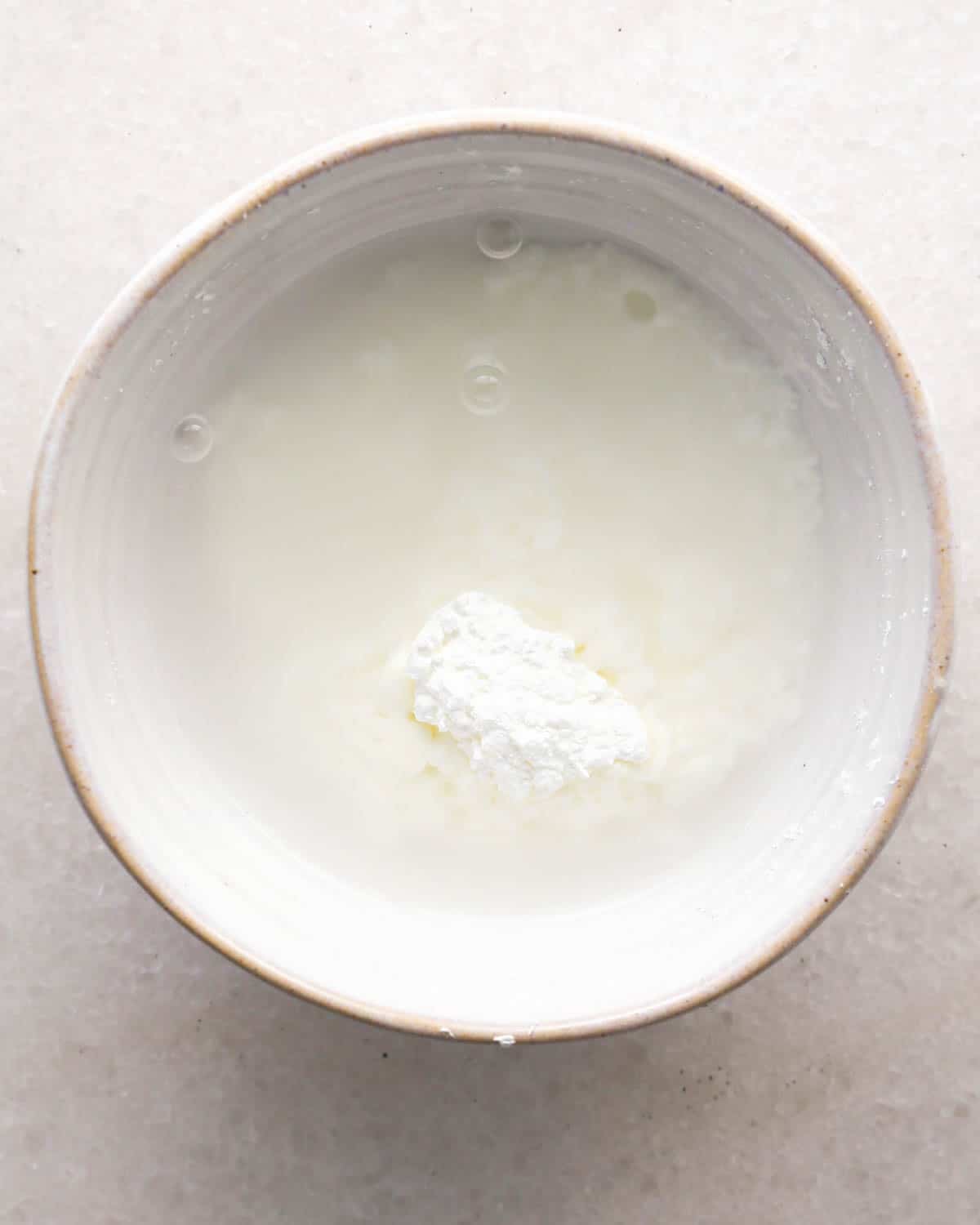 making chocolate raspberry cake filling - cornstarch and water in a ceramic glass bowl before mixing