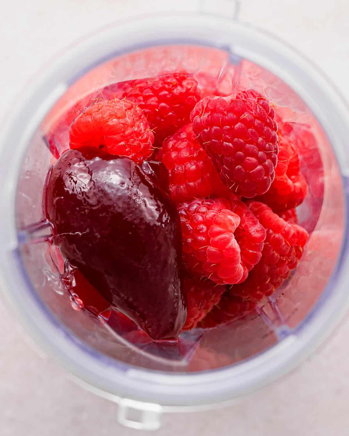 making chocolate raspberry cake filling - raspberries and jam in a small blending container before blending