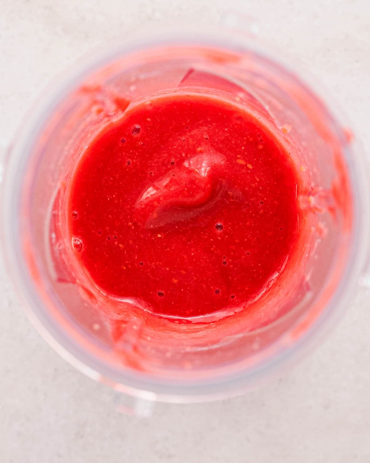 making chocolate raspberry cake filling - raspberries and jam in a small blending container after blending