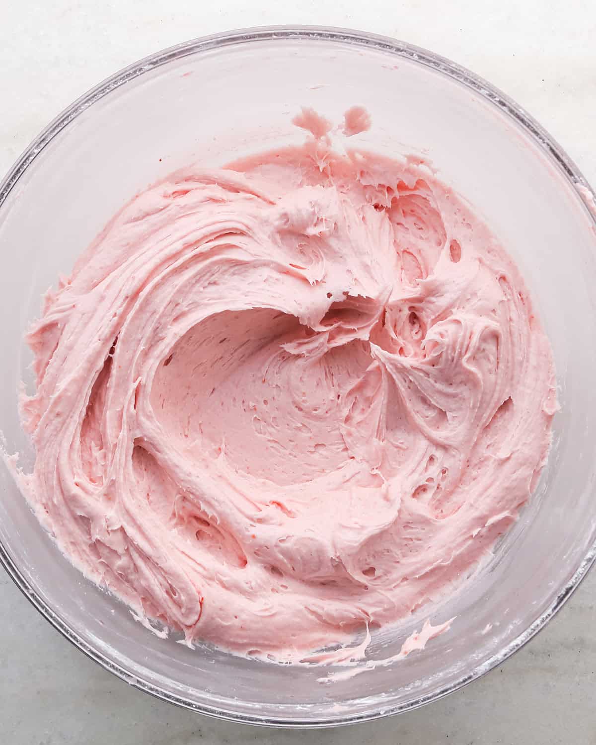 raspberry buttercream frosting in a glass bowl