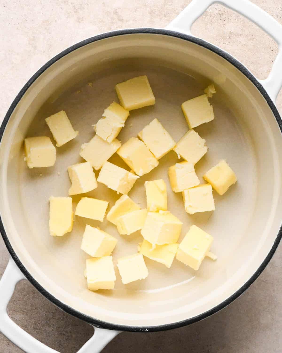 making brown butter banana bread - cubed butter in a white pan with a black rim