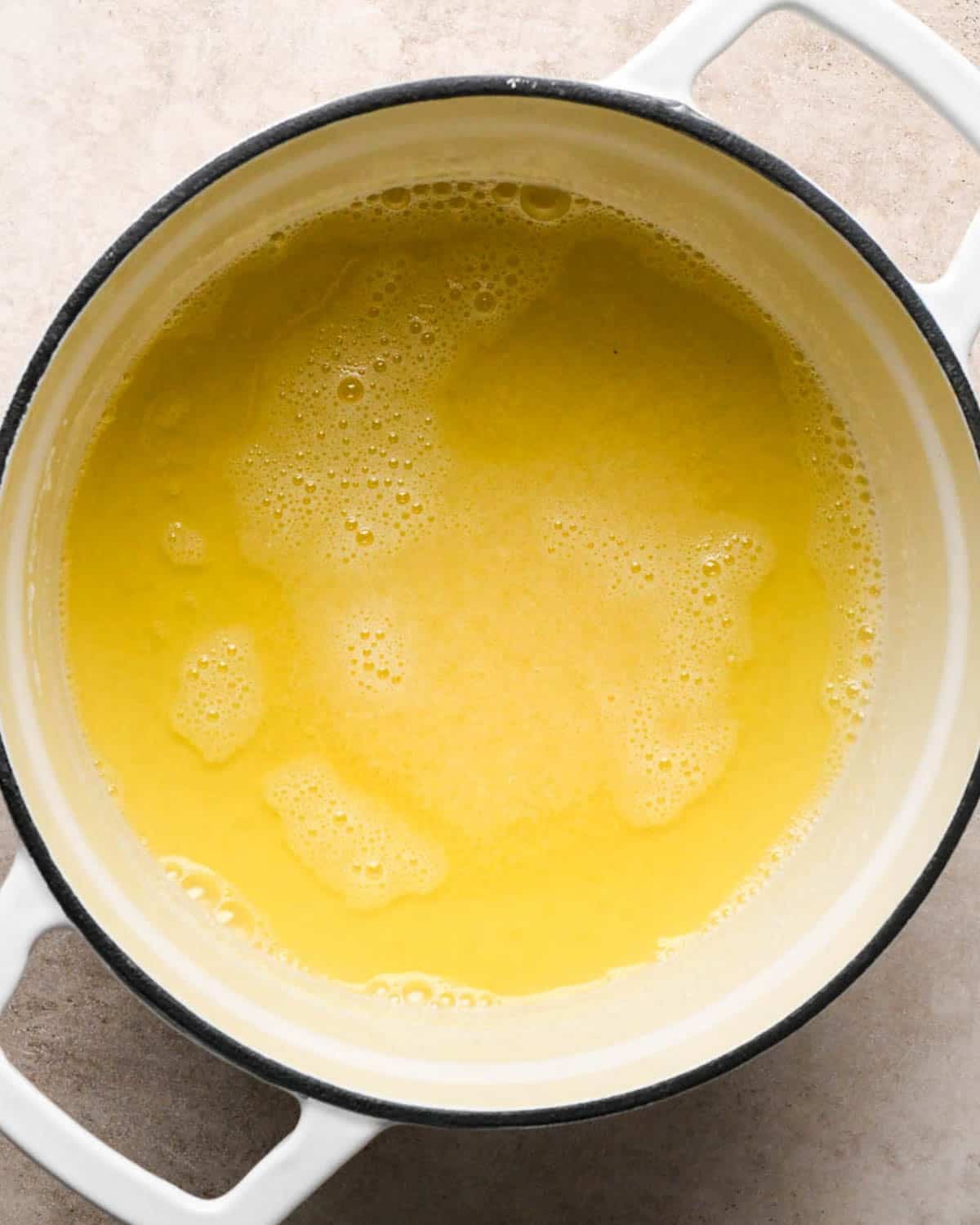 browning the butter for brown butter banana bread in a white pot - butter is melted
