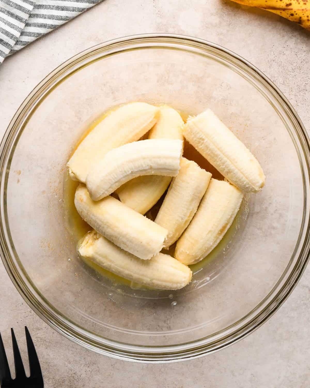 making brown butter banana bread - bananas added to the brown butter in a glass bowl before mashing