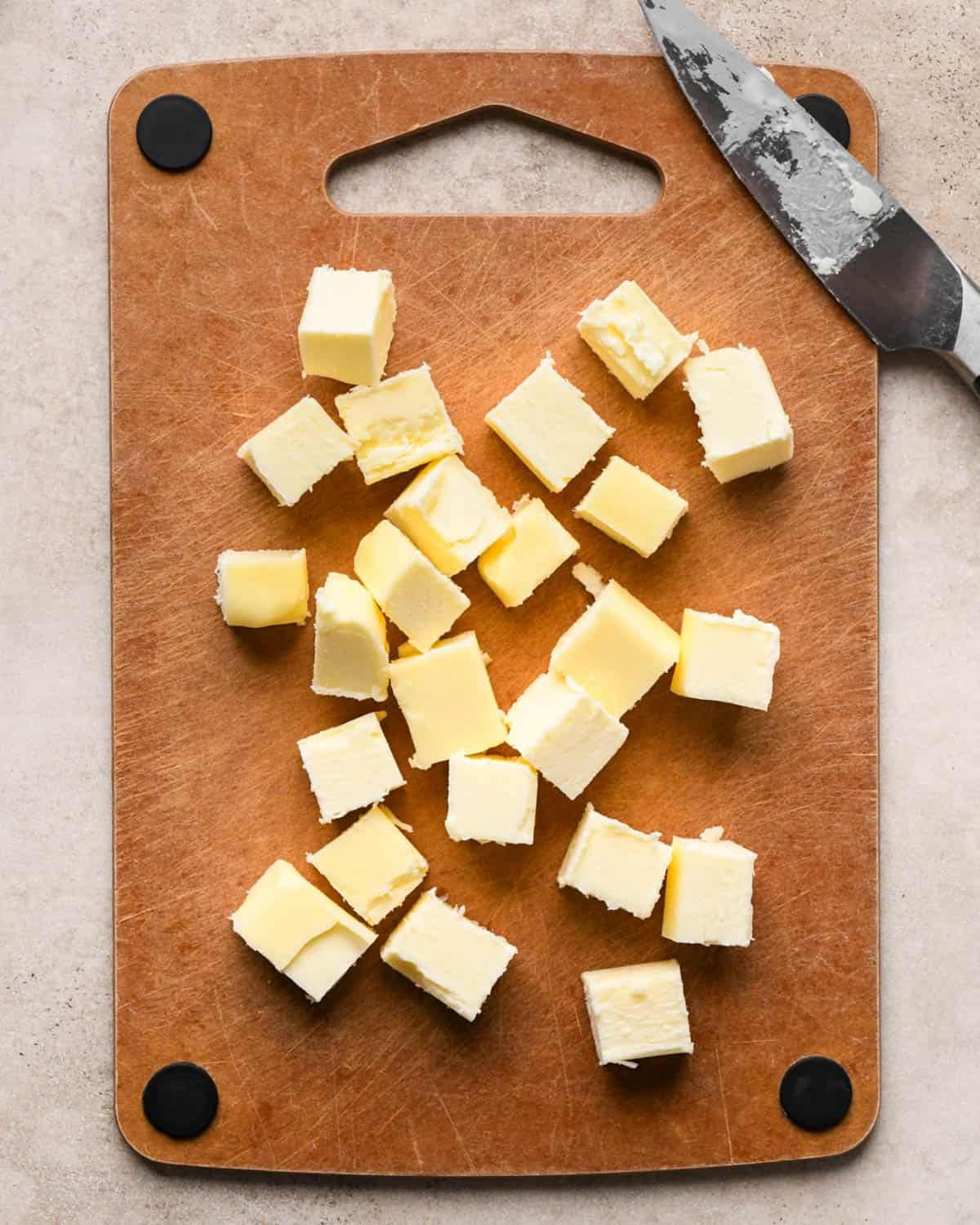 making brown butter banana bread - cubed butter on a cutting board with a knife