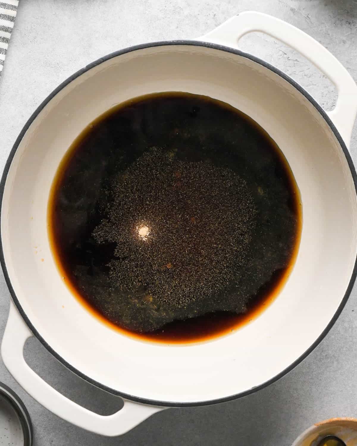 making teriyaki sauce for teriyaki meatballs - ingredients in a white saucepan with a black rim
