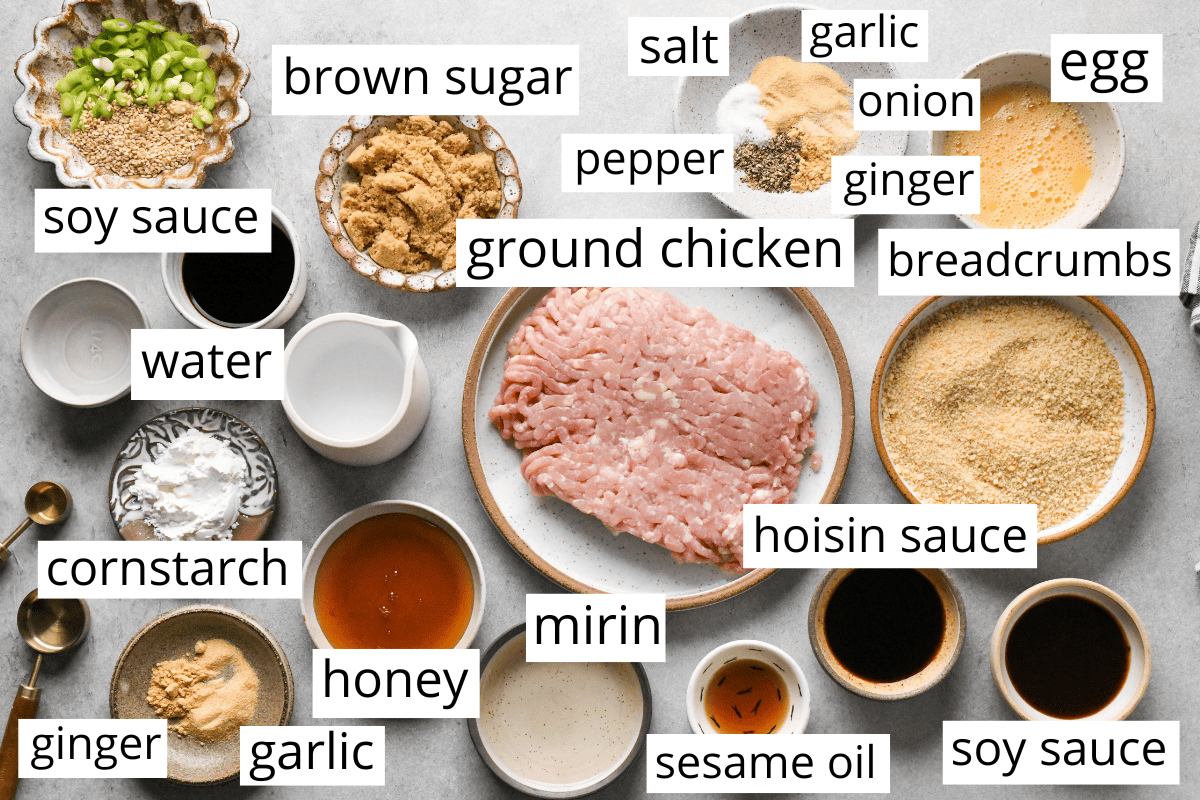overhead photo of the ingredients in this teriyaki chicken meatballs recipe, all in bowls and labeled like ground chicken, breadcrumbs, sesame oil, mirin, and more