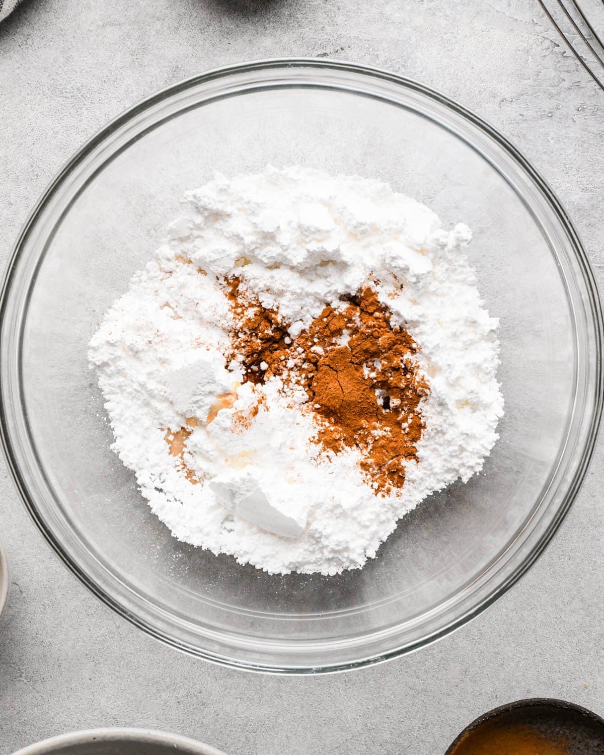 making icing for homemade pop tarts - powdered sugar, milk and cinnamon in a glass bowl before mixing