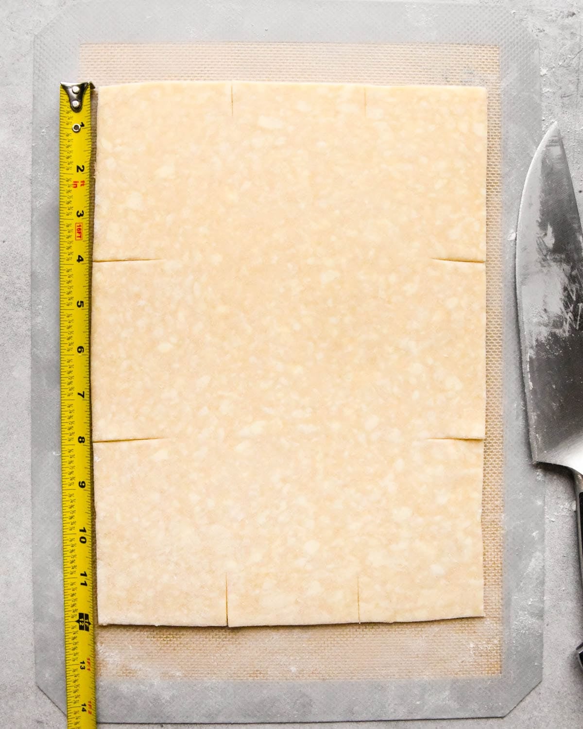 making homemade pop tarts - a rectangle of dough being scored before cutting using a tape measure to measure the size