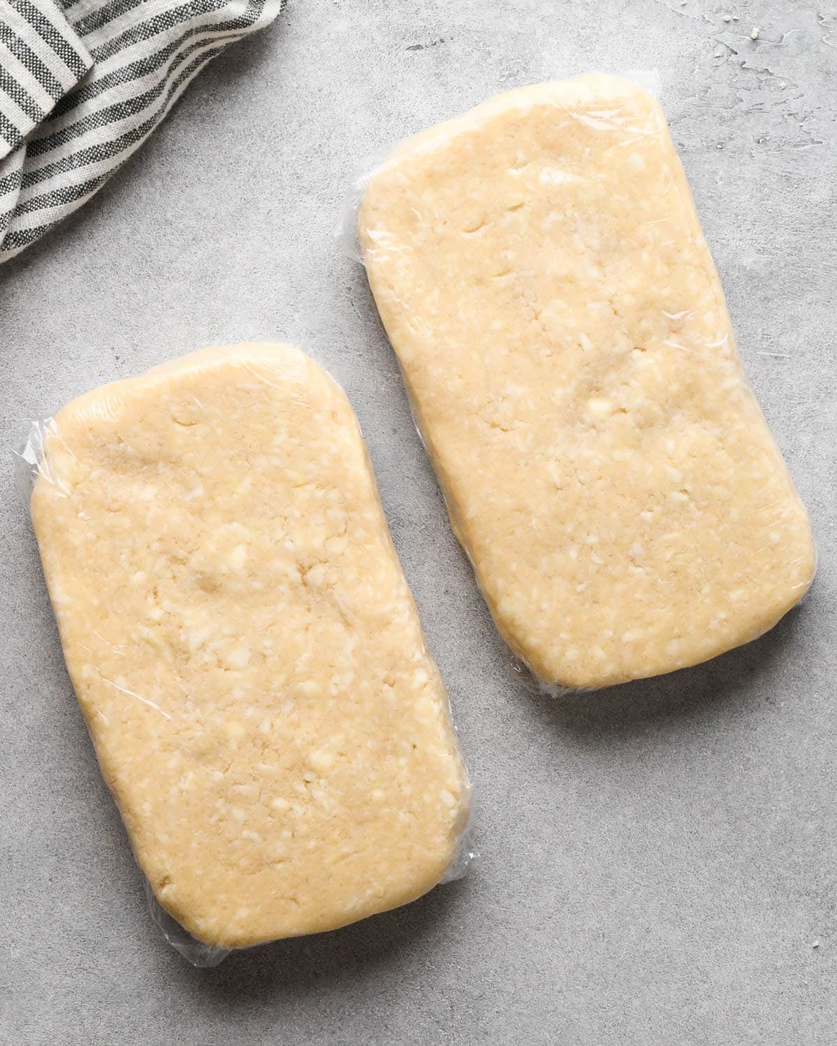 making homemade pop tarts - dough in two rectangular pieces wrapped in plastic wrap