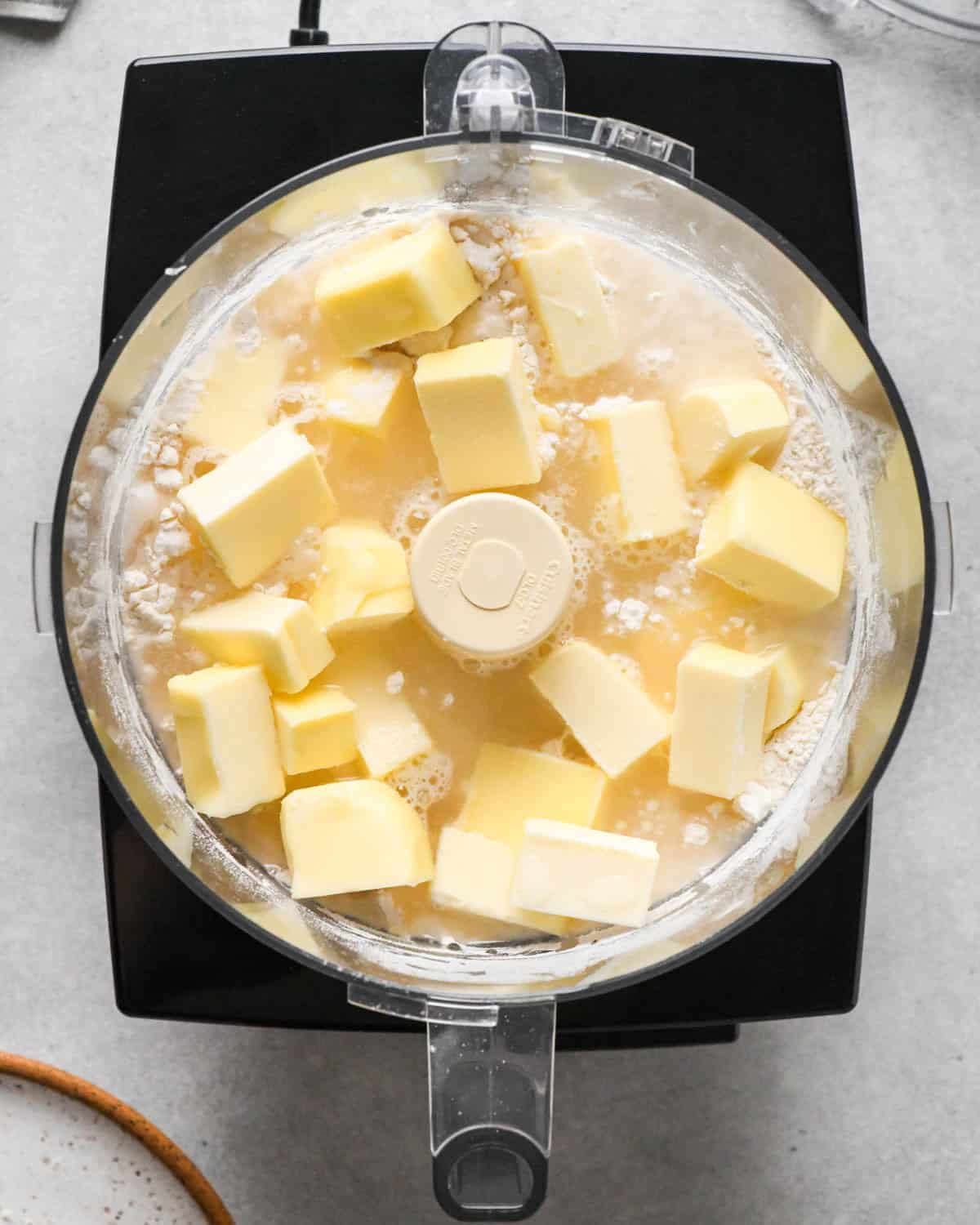 making homemade pop tarts - butter and water added to the dry ingredients in the container of a food processor fitted with the "S" blade before mixing
