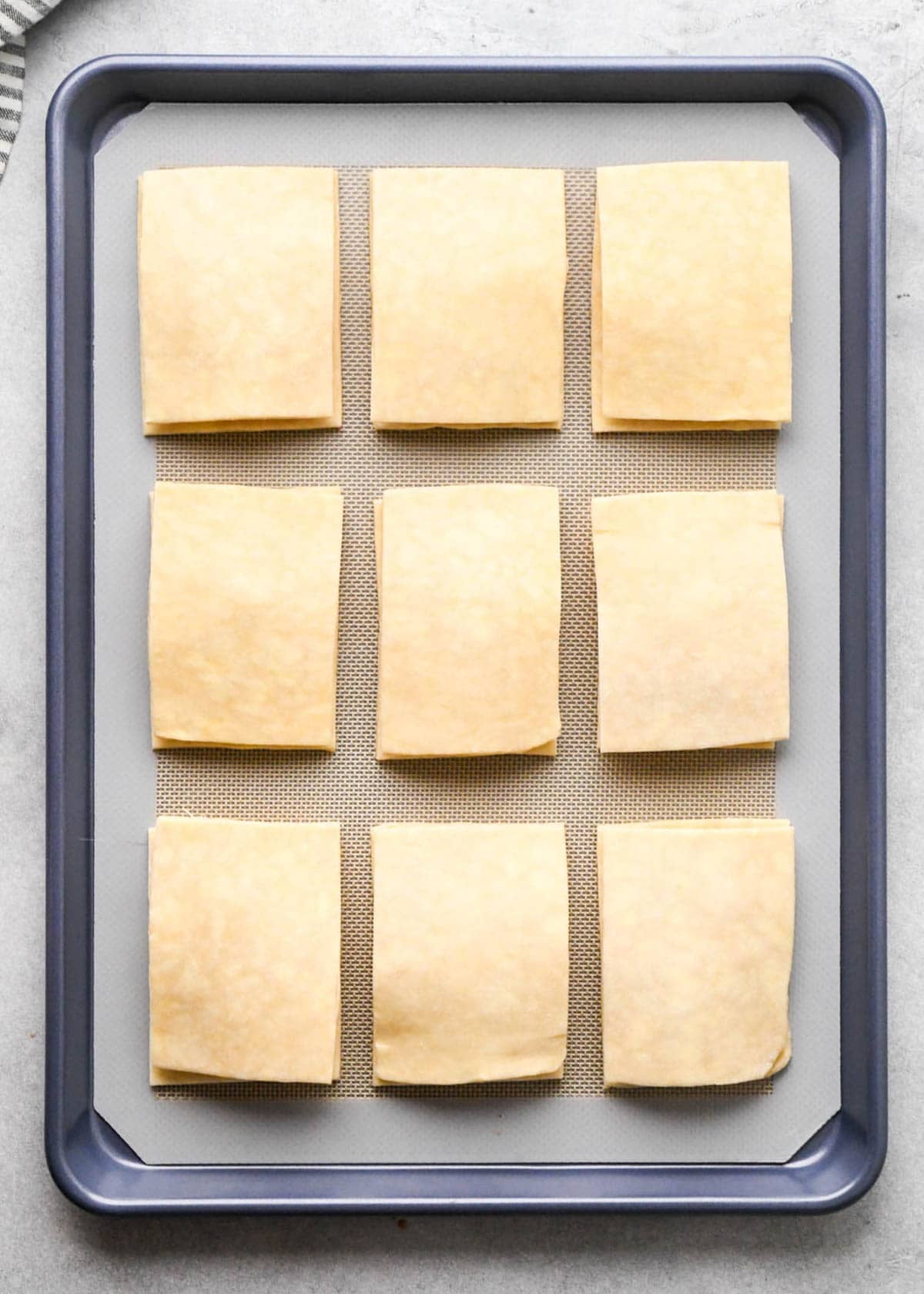 assembling apple hand pies - 9 pies with the top crust on a parchment lined baking sheet
