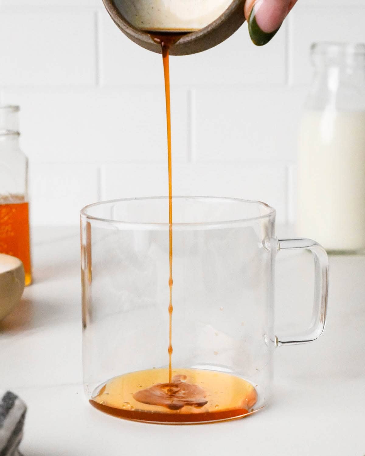 how to make a chai latte - vanilla being poured into a glass mug