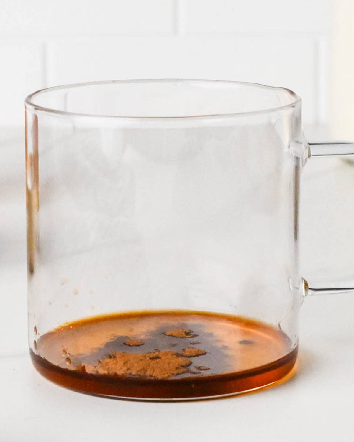 how to make a chai latte - cinnamon added to the honey and vanilla in a glass mug
