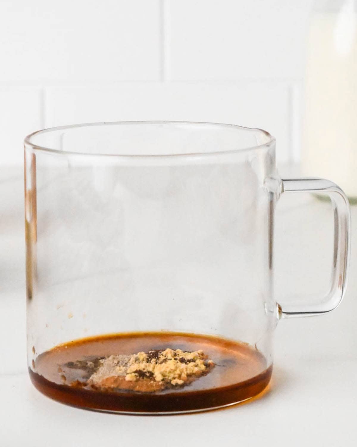how to make a chai latte - aground cloves, ginger and cardamom added to a glass muf