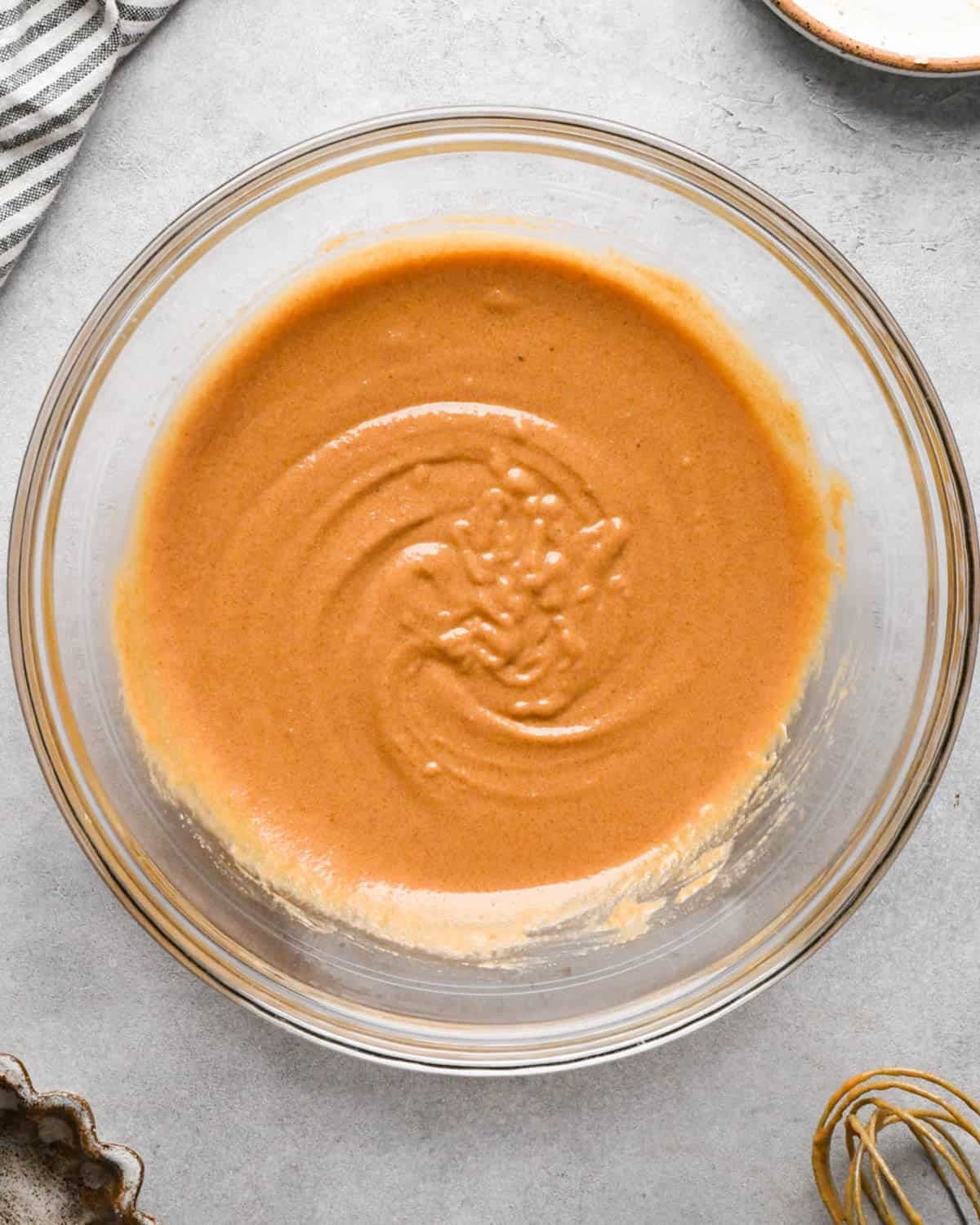 making peanut butter blondies - butter, peanut butter, white sugar and brown sugar in a glass mixing bowl after mixing