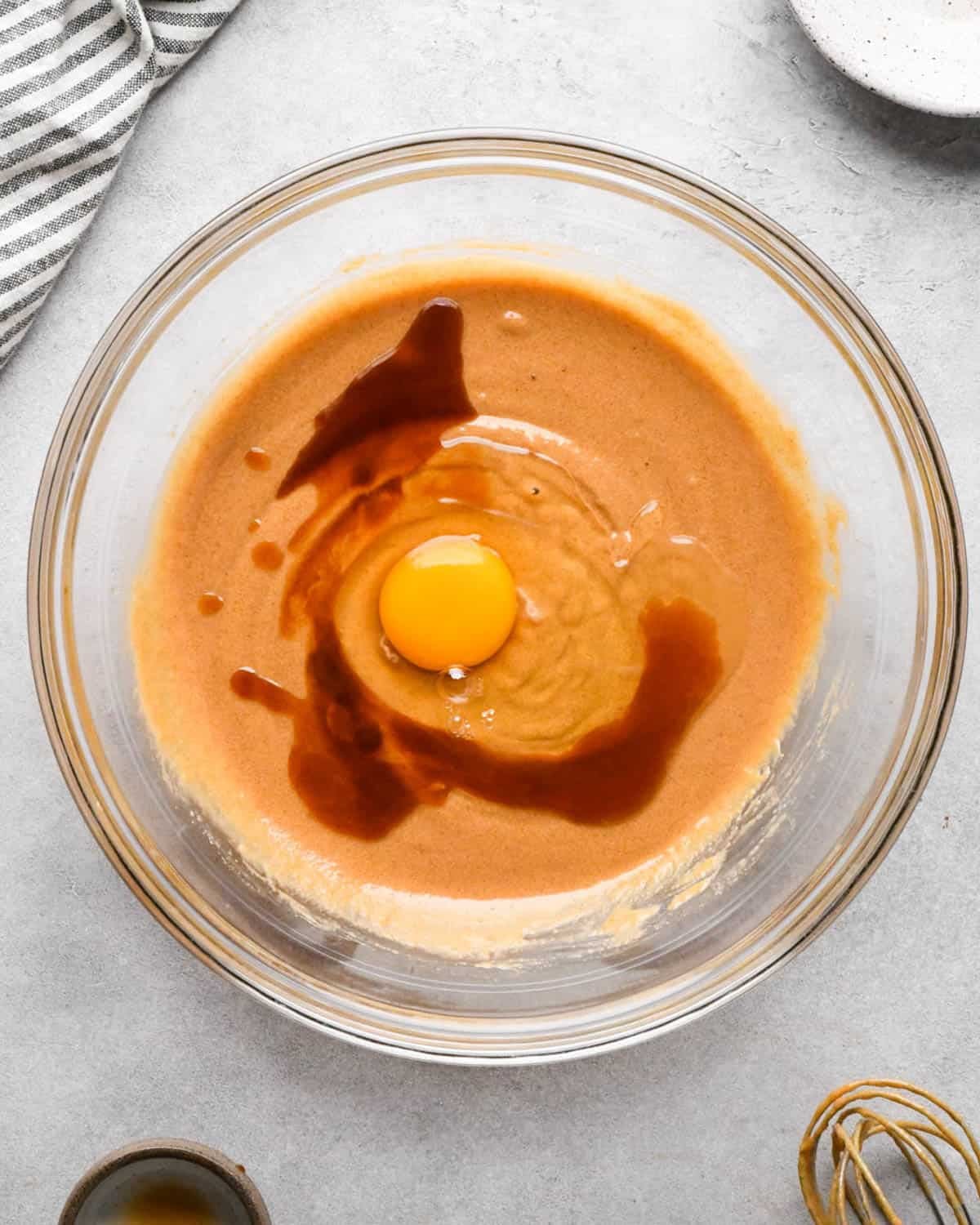 making peanut butter blondies - vanilla and egg added to the wet ingredients in a glass mixing bowl before whisking