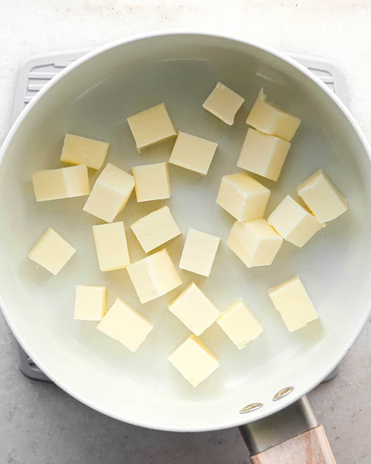making brown butter cookie bars - cubed butter in a white saucepan