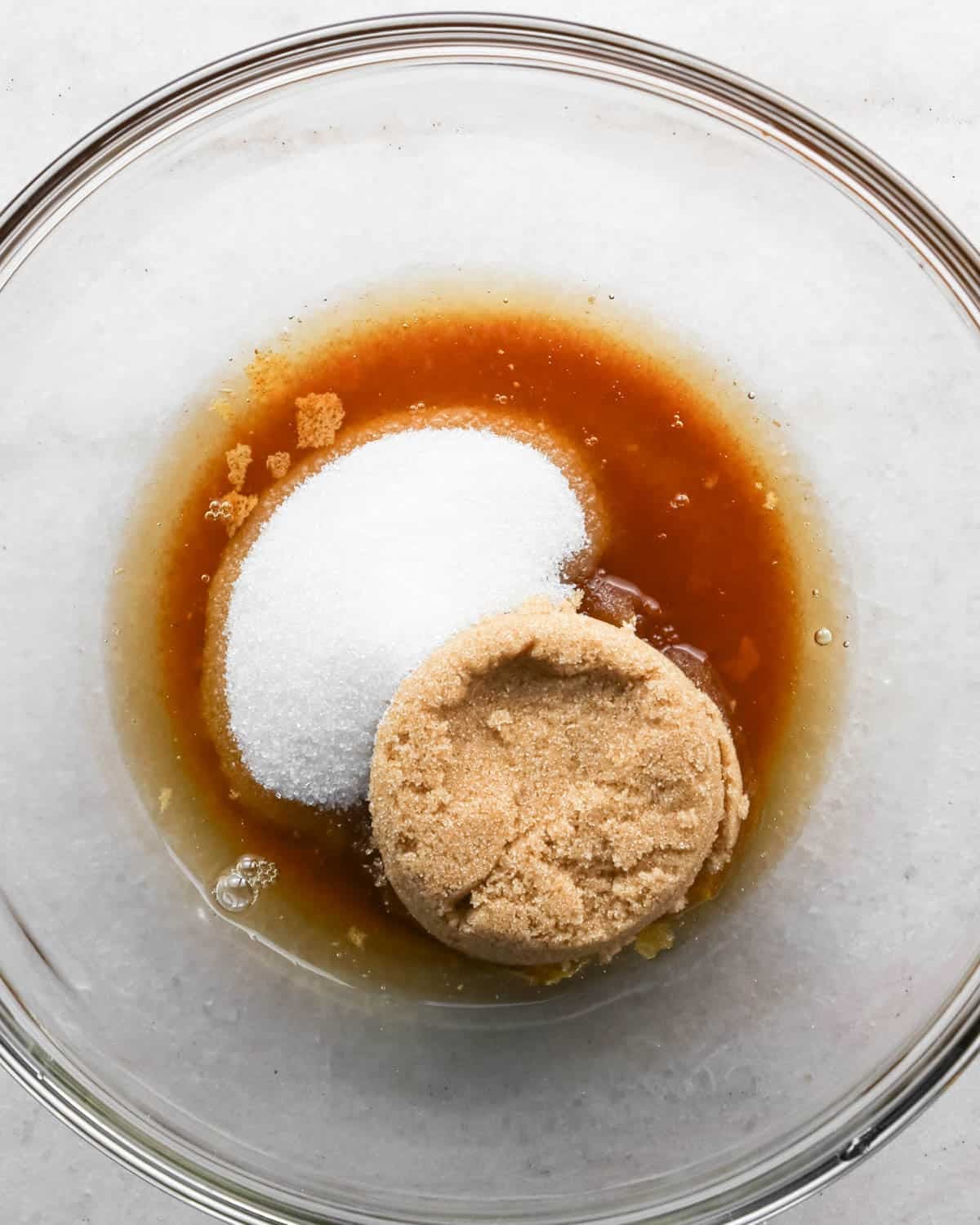 making brown butter cookie bars - browned butter, white sugar and brown sugar in a glass mixing bowl before mixing