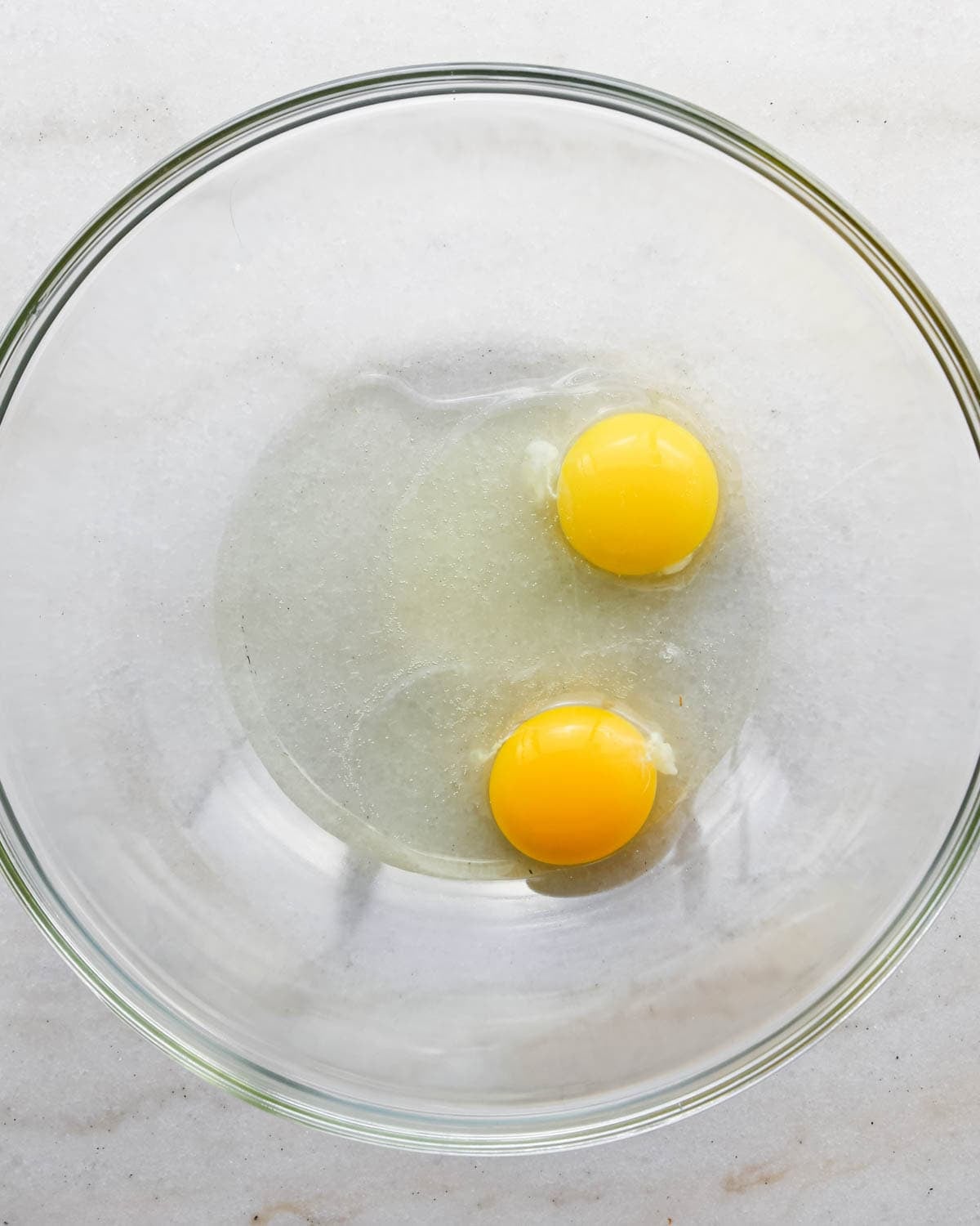 making candy halloween brownies - two eggs in a glass mixing bowl