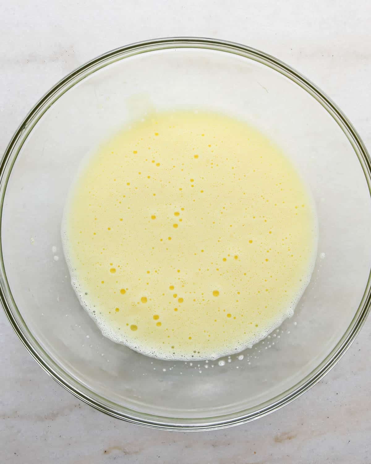making candy halloween brownies - two eggs after being beaten for one minute in a glass mixing bowl
