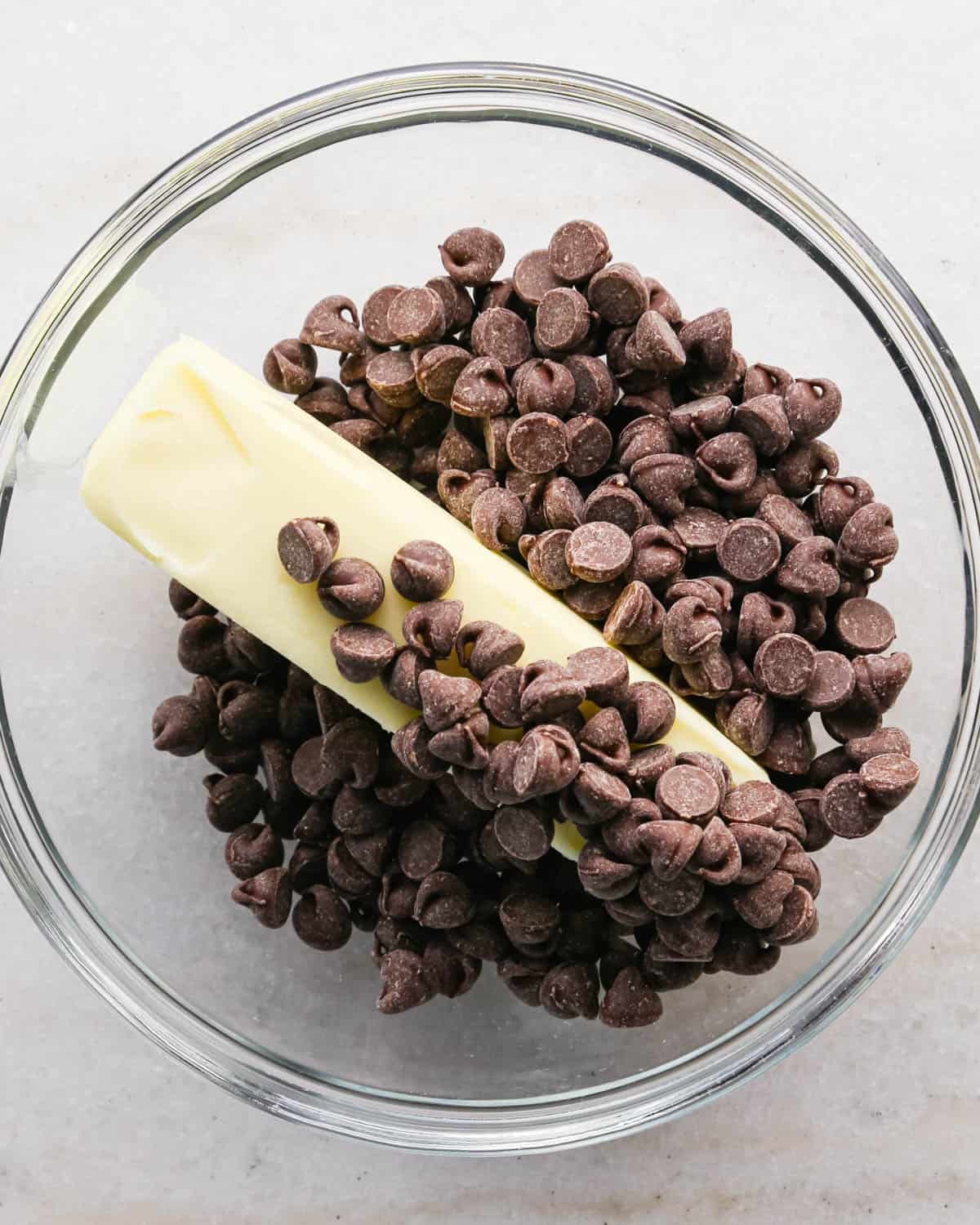 making candy halloween brownies - a stick of butter and chocolate chips in a glass mixing bowl