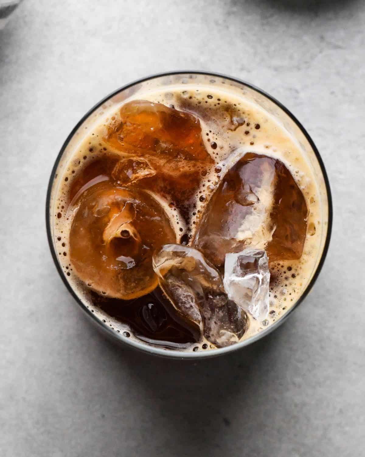 how to make an iced vanilla latte - overhead photo of brewed espresso poured into a glass of ice