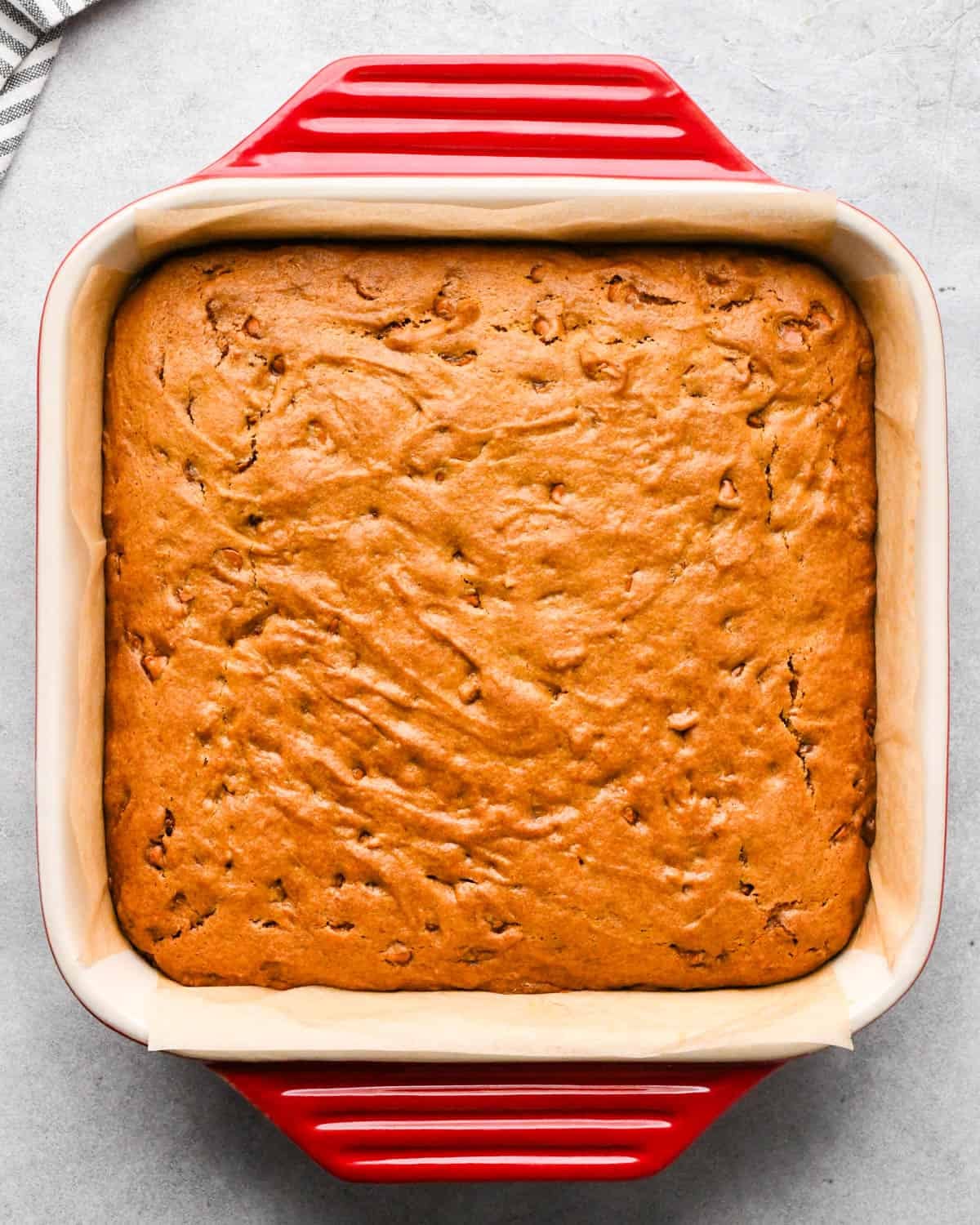 pumpkin blondies in a 9" red ceramic baking dish after baking