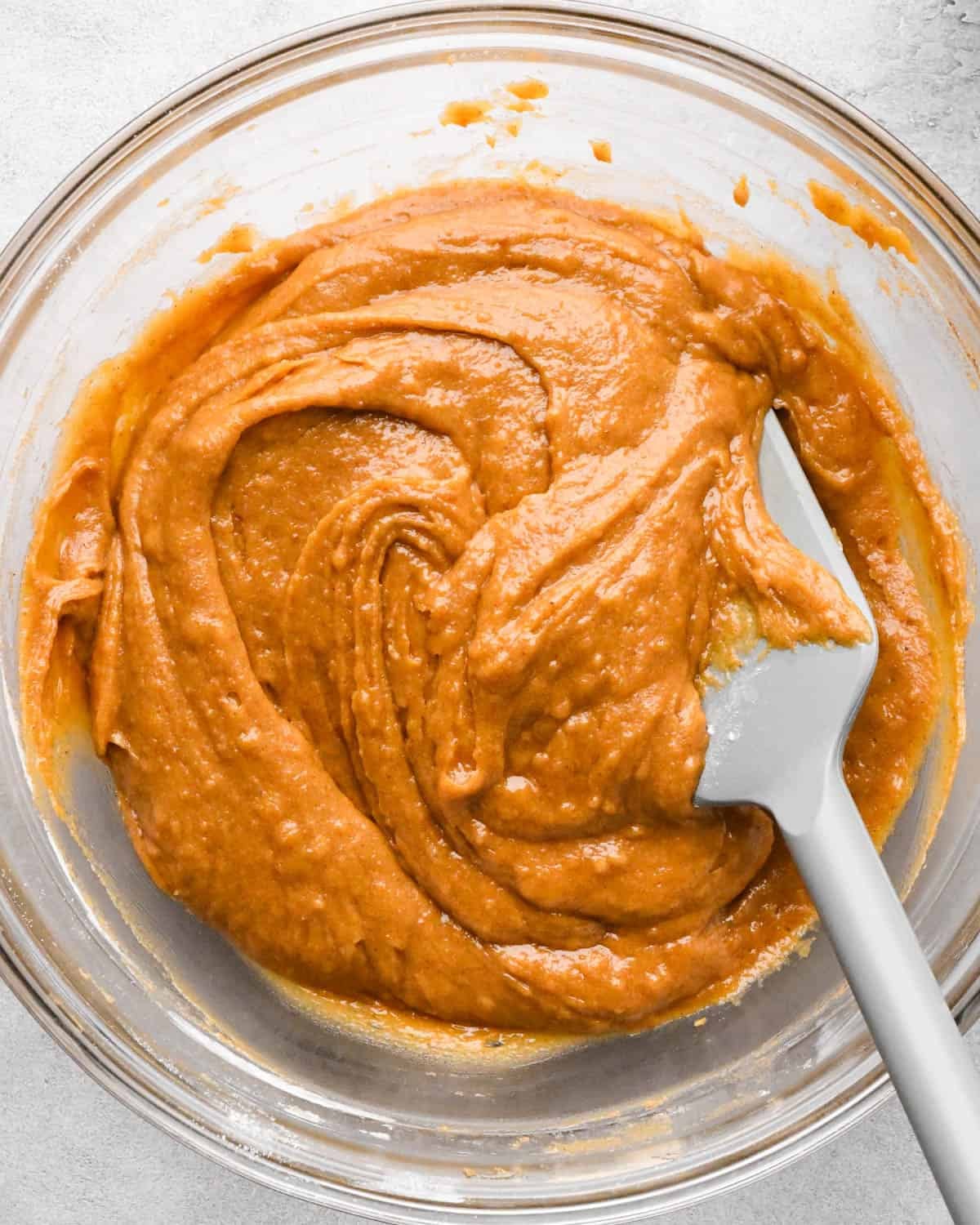 making pumpkin blondies - batter in a glass mixing bowl with a gray spatula