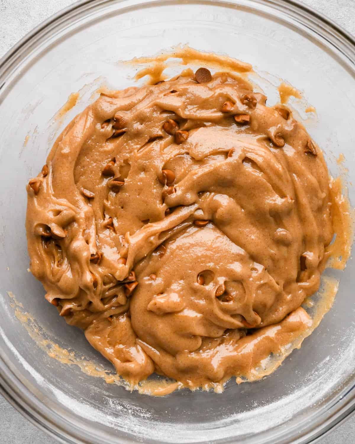 making snickerdoodle blondies -final batter with cinnamon chips mixed in in a glass bowl