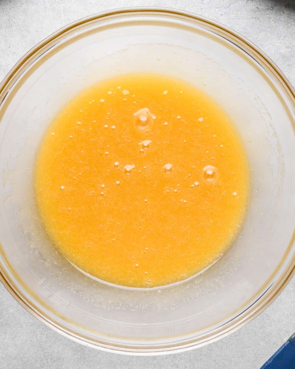 making snickerdoodle blondies -wet ingredients in a glass bowl on a gray surface