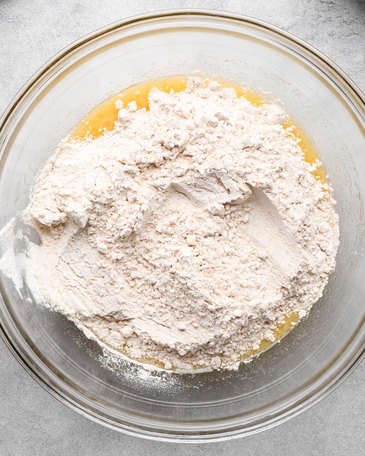 making snickerdoodle blondies -dry ingredients added to the wet ingredients in a glass bowl before mixing
