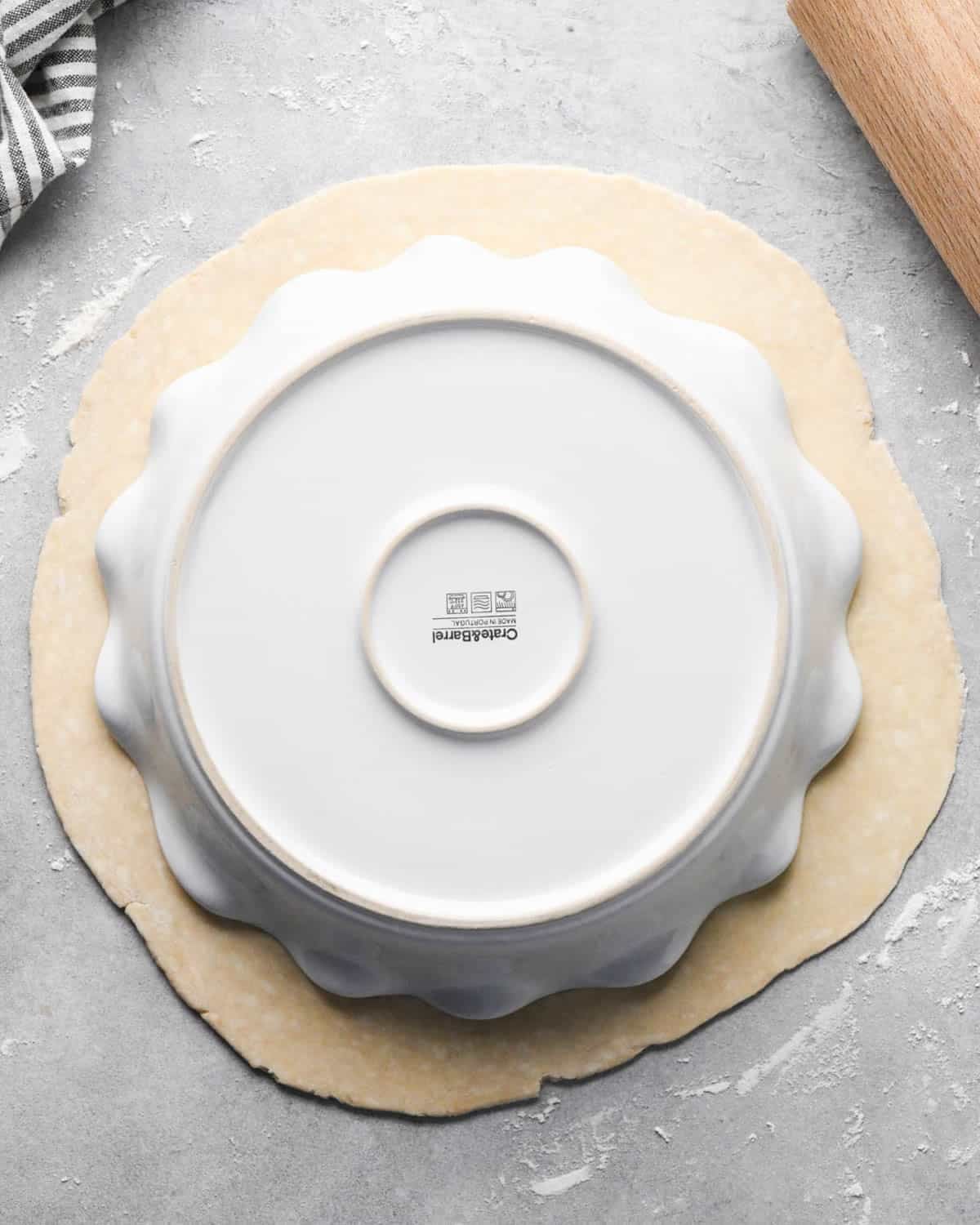 making apple cranberry pie crust - one disc of dough rolled into a circle with the pie plate upside down on top of it
