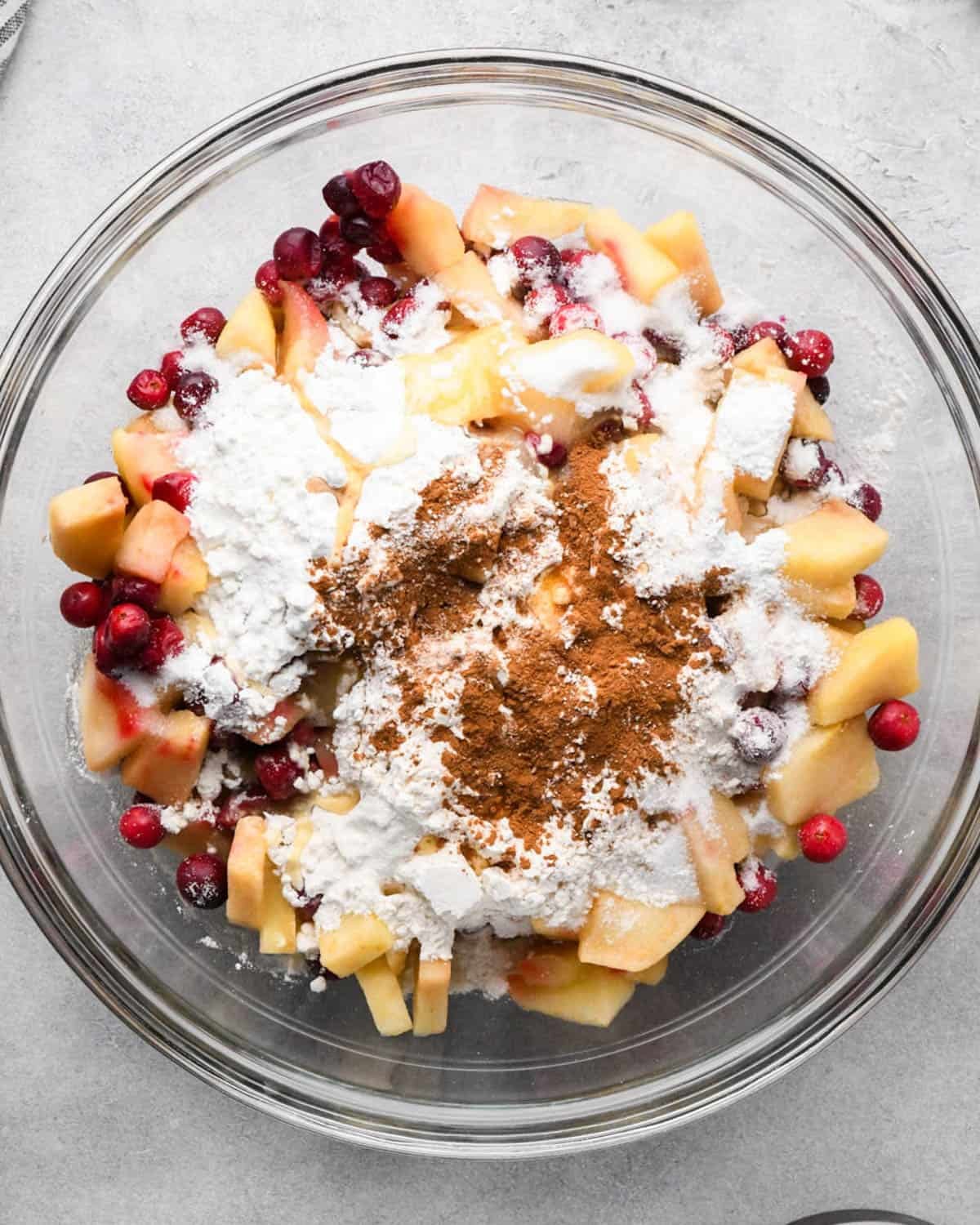 making cranberry and apple pie - filling ingredients in a glass bowl before mixing