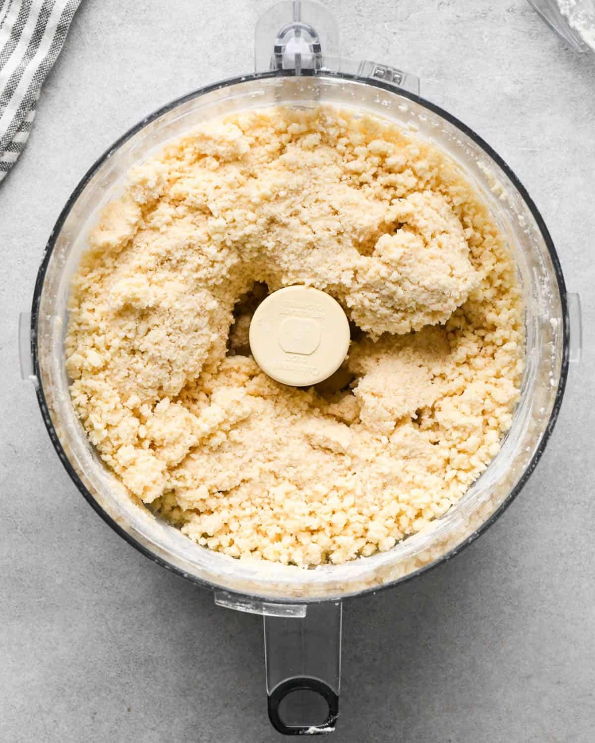making apple cranberry pie crust - crust mixture in a food processor