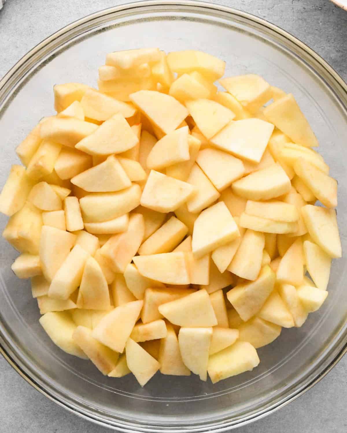 making cranberry and apple pie - peeled, cored and sliced apples in a glass bowl after being microwaved for 3 minutes
