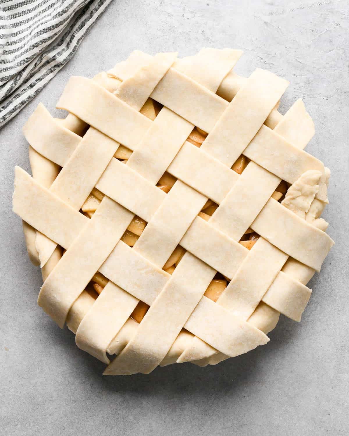 making caramel apple pie - lattice pie crust top put on top of the filling in a pie dish