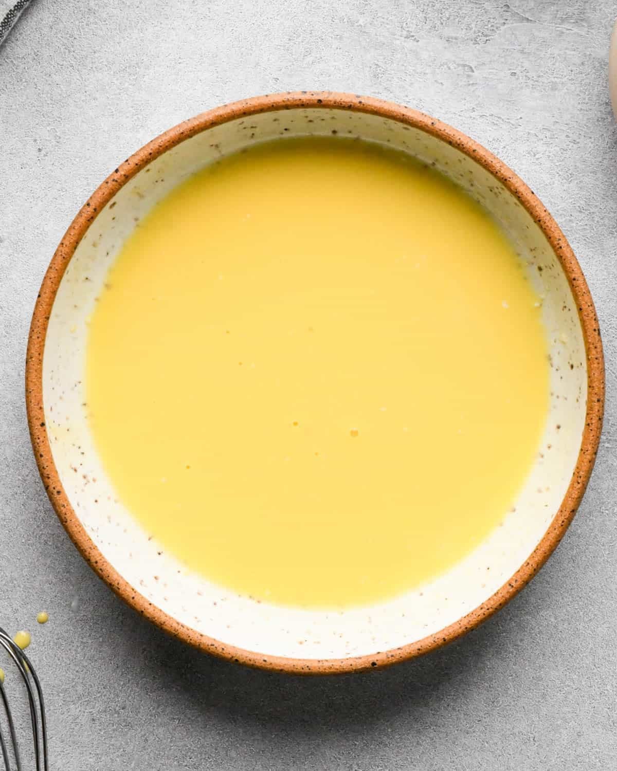 making caramel apple pie - egg wash in a small ceramic bowl after mixing