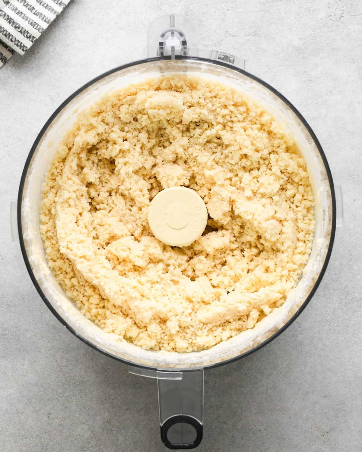making crust for caramel apple pie - butter and water added to the dry ingredient sin a food processor fitted with the S blade after mixing